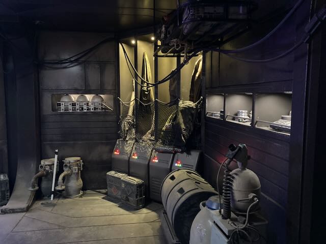 Practical-lit cargo-bay set with built-in source lighting and dressed sci-fi crates.